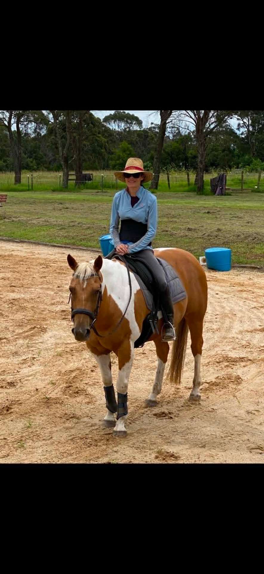 Chloe on horseback with Jasper, a palomino paint horse, in the arena