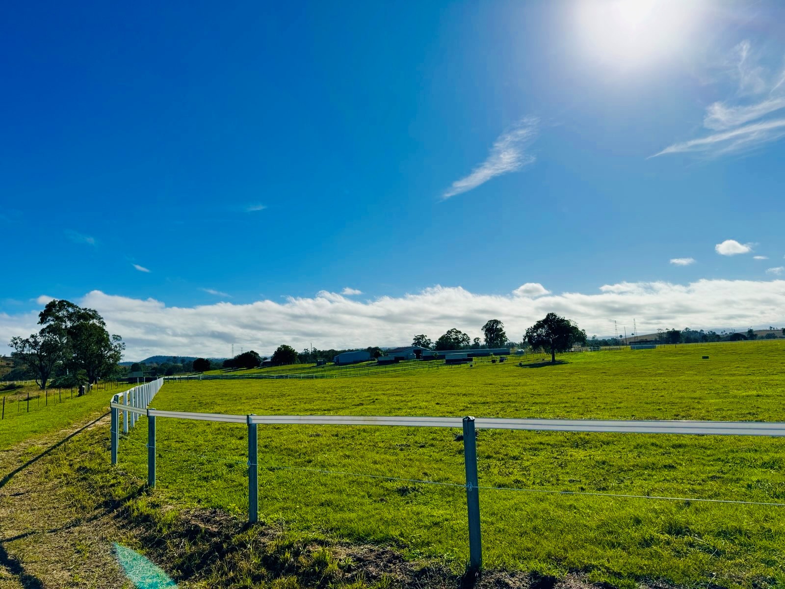 White post-and-rail fencing leading toward the sanctuary buildings